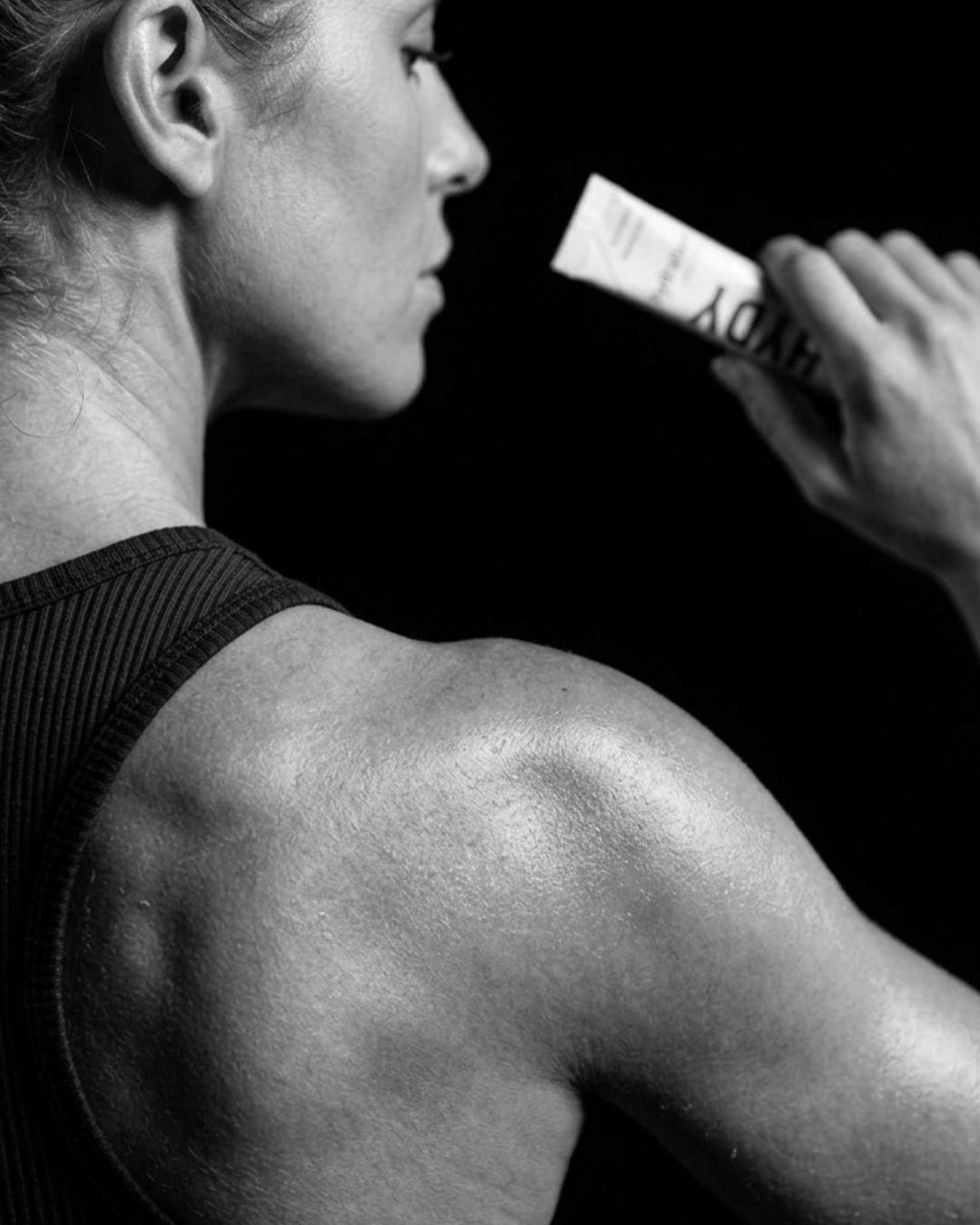 Atleta com suor nos ombros bebendo HYDY Hydration direto do stick
